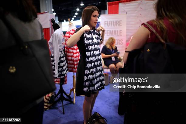 Young woman looks at a dress with an elephant pattern for sale in the Exhibitor Hub during the first day of the Conservative Political Action...