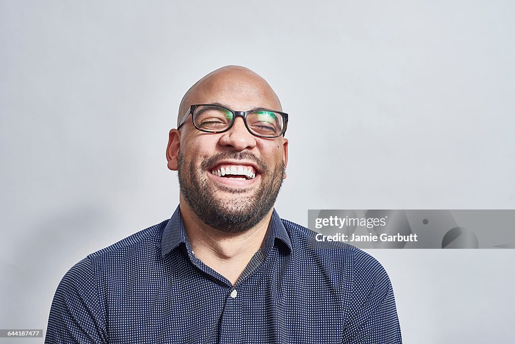Mixed race male laughing with his head back