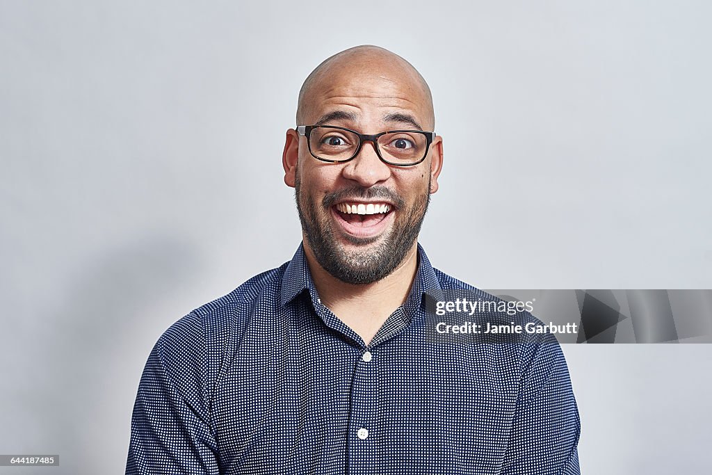 Mixed race bald British male looking surprised