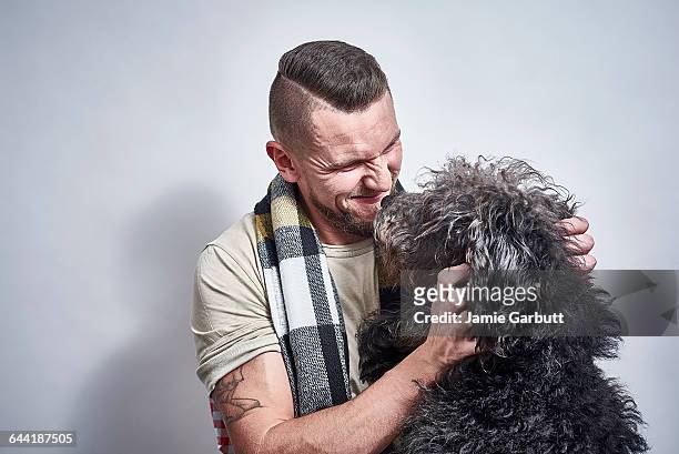 well groomed male in his early 30's and his dog - labradoodle stock-fotos und bilder