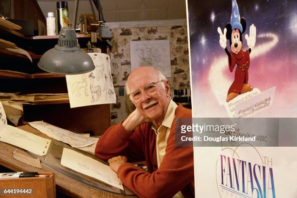 Ollie Johnston, an animator who worked on Disney's Fantasia, sits inside his studio next to a promotional movie poster.