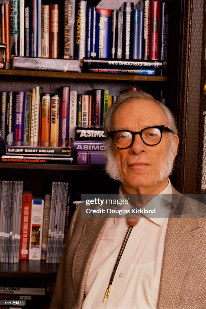 Author and Scientist Isaac Asimov Standing Next to a Book Shelf