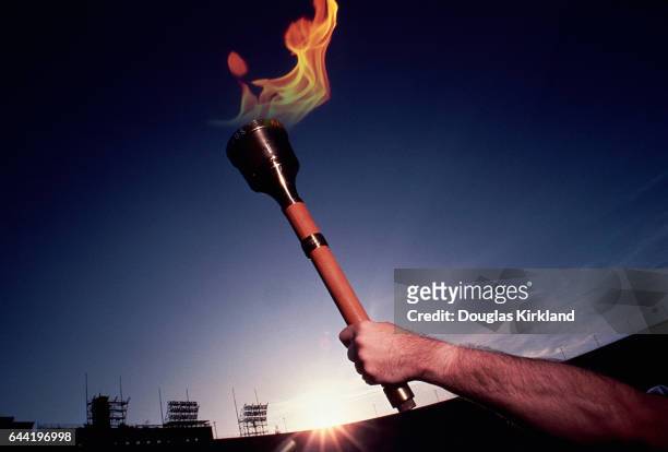 Man holds up the olympic torch at the Los Angeles Coliseum for the 1984 Summer Olympics.