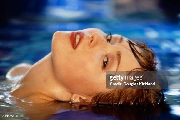 American actress Nina Siemaszko leans her head back in a pool during the filming of the 1992 motion picture Wild Orchid II: Two Shades of Blue. The...