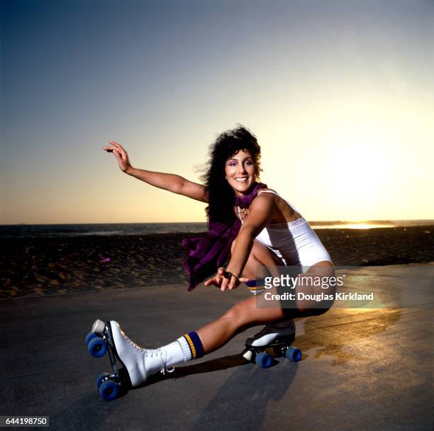 Singer and actress Cher, wearing a white swimsuit, shows off her roller skating moves at Venice Beach, California.