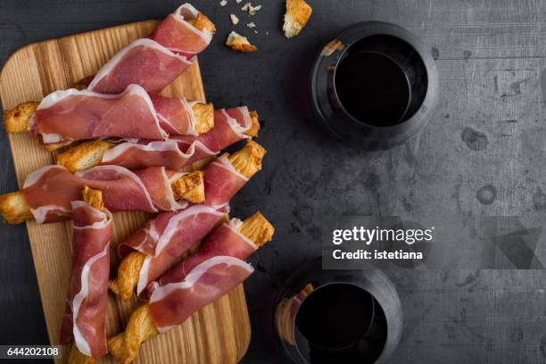 puff pastry cheese sticks with cured ham - wine glass finger food stock-fotos und bilder