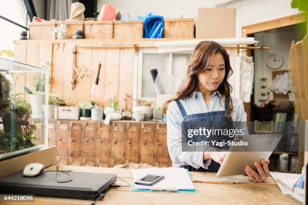 young female worker working in flower shop. - asia lady selling flower stock pictures, royalty-free photos & images