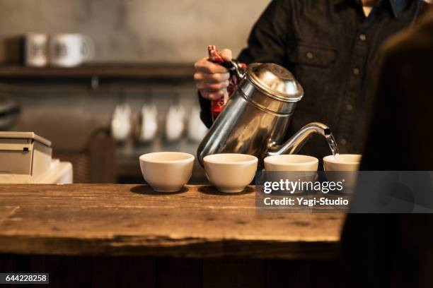 male cafe owner preparing coffee in coffee shop - cafe culture stock pictures, royalty-free photos & images