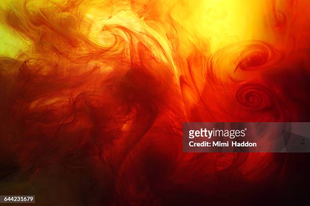 yellow, red and black pigment in liquid swirls - yellow smoke stock pictures, royalty-free photos & images