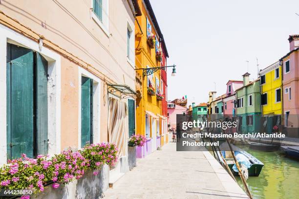 laguna (lagoon) di venezia, burano, a canal with the typical colourful houses - laguna di venezia stock-fotos und bilder