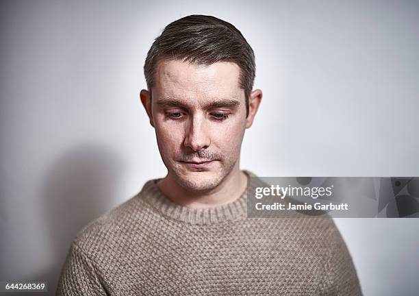 early 30's british male with a sad expression. - mirar hacia abajo fotografías e imágenes de stock
