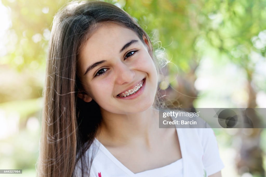Ziemlich junges Mädchen tragen Zahnspangen fröhlich lächelnd
