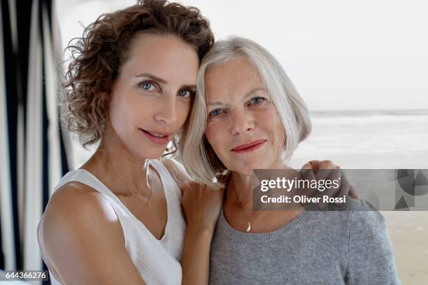 portrait of adult daughter embracing mother - collier et femme photos et images de collection