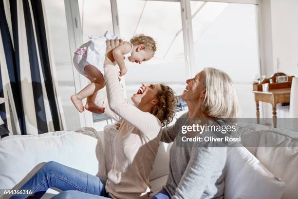 happy mother with baby girl and grandmother at home - beautiful barefoot girls imagens e fotografias de stock