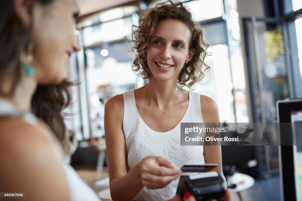 Woman in a shop paying with credit card
