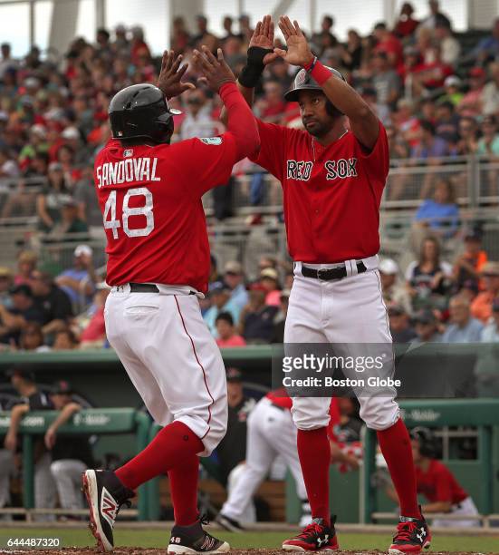 Boston Red Sox third baseman Pablo Sandoval and Boston Red Sox outfielder Chris Young high five at the plate after scoring on a three run home run by...