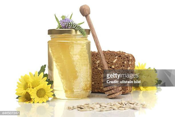 Wabenhonig mit Vollkornbrot, Honiglffel, Sonnenblumenkerne und Blumen |Wholemeal bread with honey comb, honey spoon, sunflower seeds and flowers|