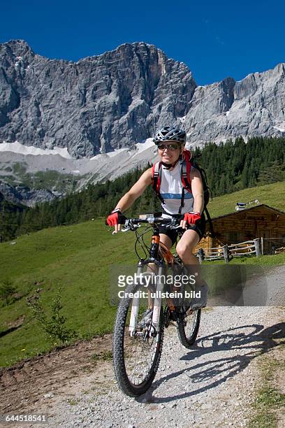 Frau mit dem Mountainbike in alpiner Landschaft