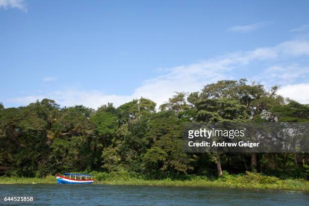 colorful passenger boat on lake with forest in background. - solentiname nicaragua stock pictures, royalty-free photos & images
