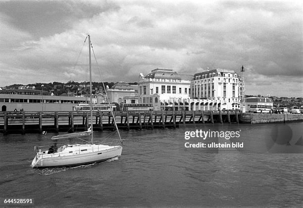 Segelboot im Hafen von Deauville, im Hintergrund ein nobles Hotel, hier fahren im Sommer an den Wochenenden die Pariser her, weil es der naechste...