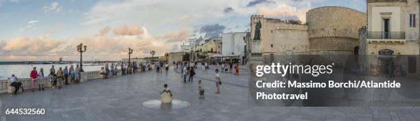 promenade along the seaside, the old town with the torre alfonsina gate on the right - otranto stock pictures, royalty-free photos & images