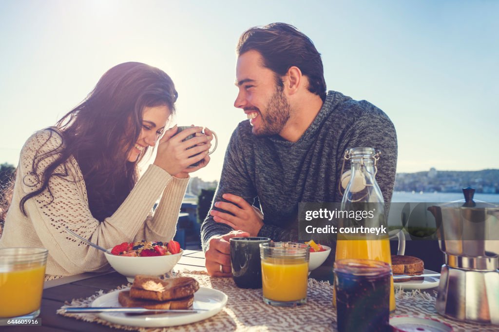 Couple eating breakfast outdoors.