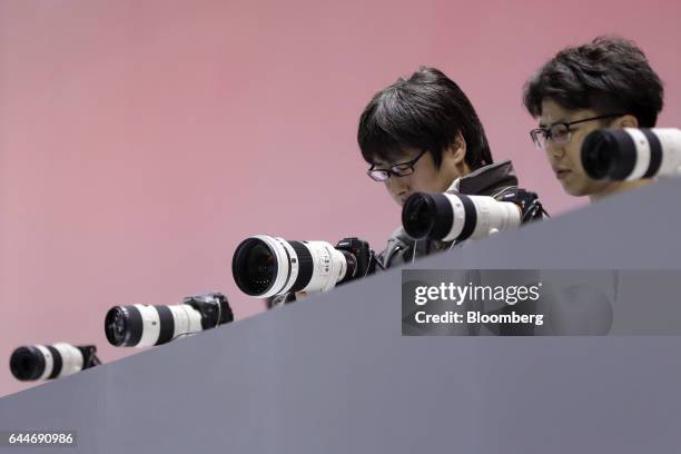 An attendee, left, tries out a Sony Corp. Alpha 7R II full-frame mirrorless interchangeable lens digital camera mounted with a Sony 300mm f/2.8 G SSM...
