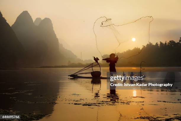 catching the sun - net-fishing on li river, yangshuo county, china - tribal head gear in china stock pictures, royalty-free photos & images