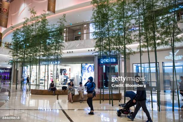 Visitors walk past a Longchamp SAS store, left, a Qeelin Ltd. Jewellery store, center, and a Montres Breguet SA watch store in the Promenade Central...