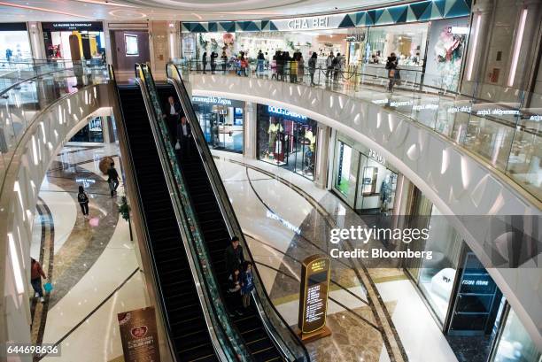 Visitors ride an escalator in the Promenade Central shopping area at the Galaxy Macau Phase 2 casino and hotel, developed by Galaxy Entertainment...