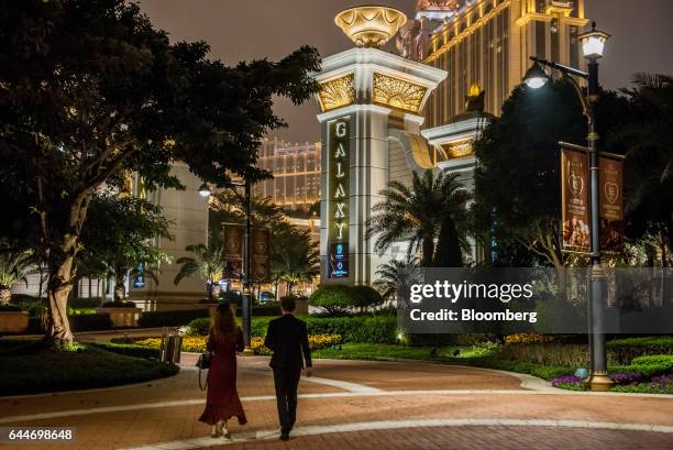 Pedestrians walk towards the Galaxy Macau casino and hotel, developed by Galaxy Entertainment Group Ltd., at night in Macau, China, on Wednesday,...