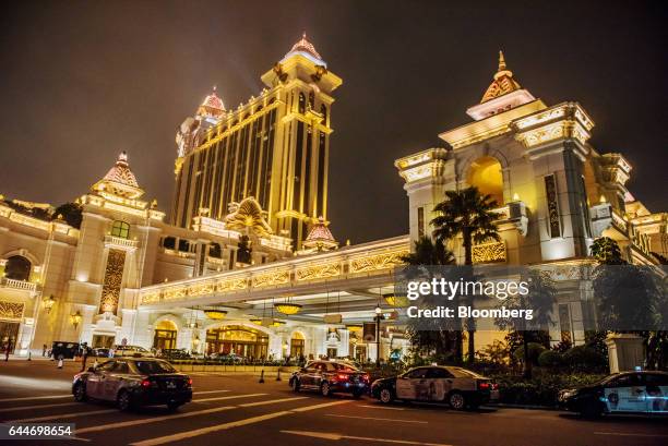 Taxis sit parked in front of the Galaxy Macau casino and hotel, developed by Galaxy Entertainment Group Ltd., illuminated at night in Macau, China,...