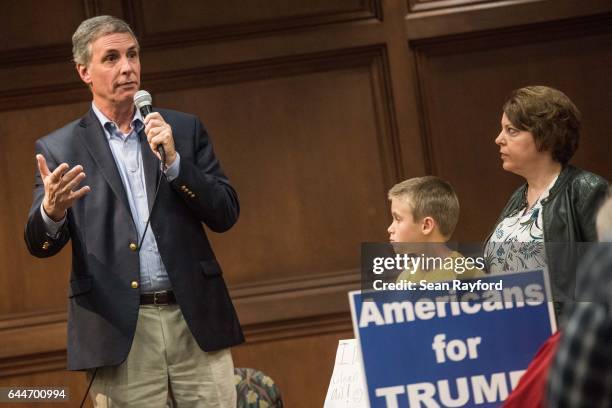 Rep. Tom Rice answers a question from Liz Bergfeld, right, and her ten year-old son, Alex Bergfeld, center, during a town hall meeting at the...