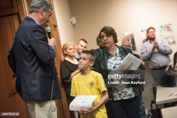Ten year-old Alex Bergfield, with his mother Liz Bergenfield, asks U.S. Rep. Tom Rice "why don't you care about the environment?" during a town hall...