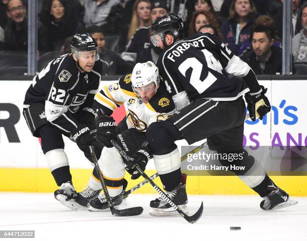 Brad Marchand of the Boston Bruins splits the defense of Derek Forbort and lTrevor Lewis of the Los Angeles Kings during the first period at Staples...