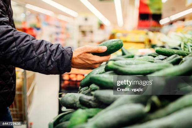 jongeman boodschappen winkelen - cucumber stockfoto's en -beelden