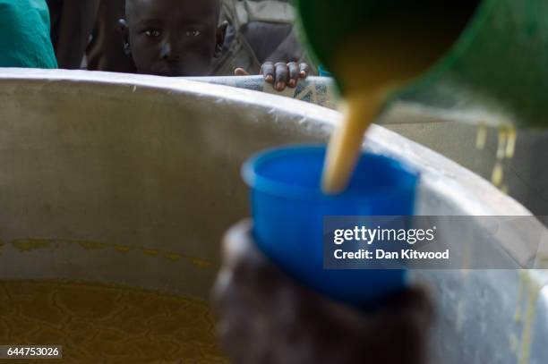 Young boy waits for a cup of porridge as WFP, the 'World Food Programme' prepares hot meals at the Imvepi Settlement on February 23, 2017 in Imvepi,...