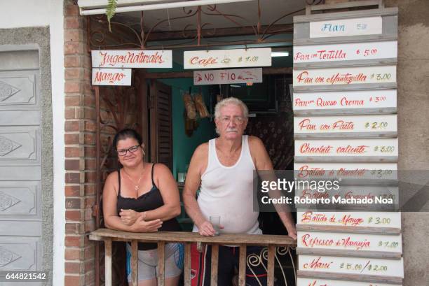 Cuban real people lifestyle: couple operating small cafeteria at their home door.