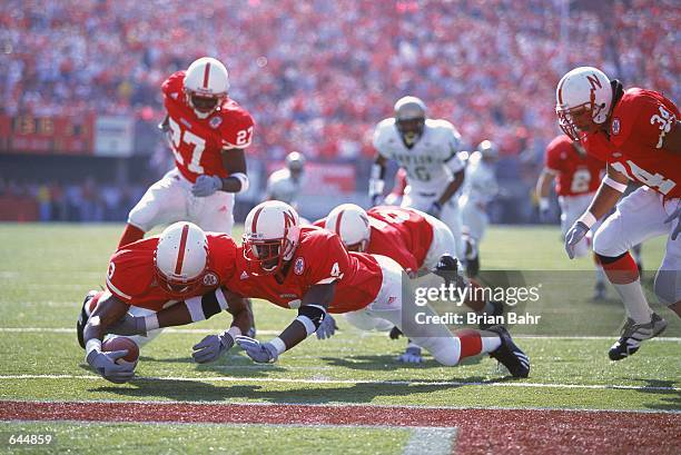 Terrell Butler and Keyuo Craver of the Nebraska Cornhuskers dive to get the ball during the game against the Baylor Bears at the Memorial Stadium in...