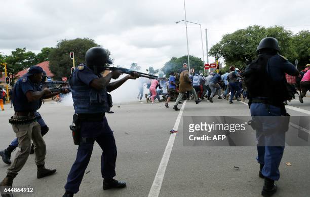 South African riot policemen fire rubber bullets to disperse Somali and foreign nationals clashing with South African nationals during a protest...