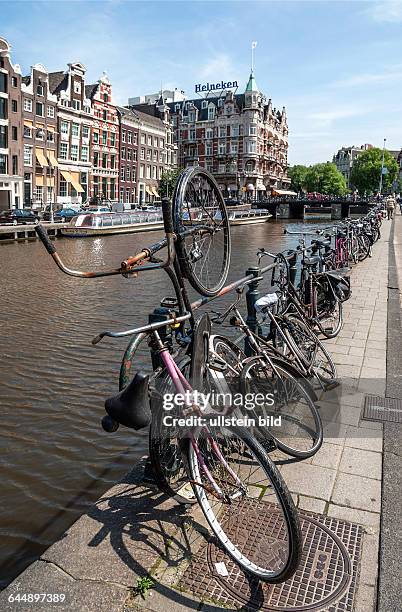 Old bicycles parked on a gracht in the inner city of Amsterdam, Netherlands.