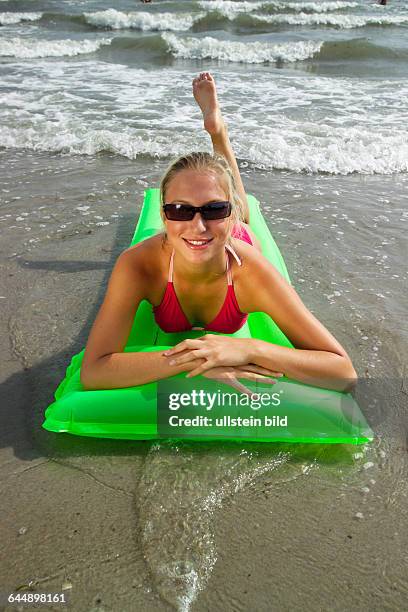 Junge Frau mit Luftmatratze am Strand, a young woman with an airmattress on the beach