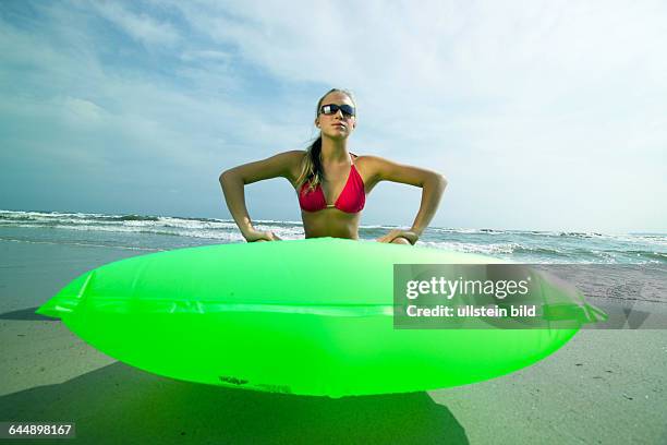 Junge Frau mit Luftmatratze am Strand, a young woman with an... News Photo