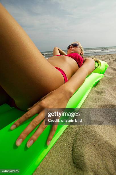 Junge Frau mit Luftmatratze am Strand, a young woman with an airmattress on the beach