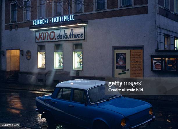 Sachsen, Wurzen: Strasse des Friedens, Kino Friedens-Lichtspiele am Abend, Aussenansicht bei regennasser Strasse, November 1990nachher: 1009212724