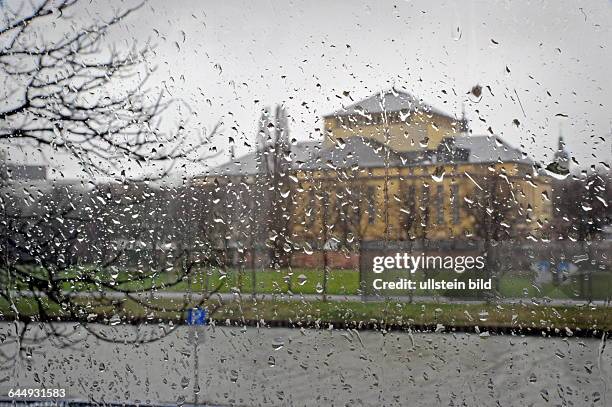 Trist und regnerisch zeigt sich die Landeshauptstadt. Blick durch eine verregnete Fensterscheibe der IHK auf das Saarländische Staatstheater in...