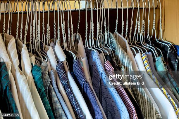 Schrank mit Herrenhemden auf Kleiderbügeln, Auswahl und Ordnung