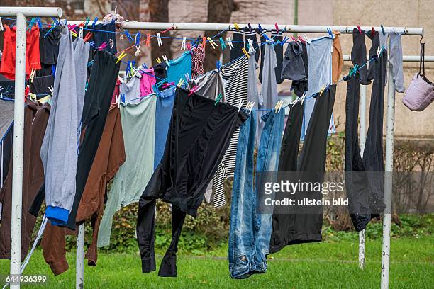 Auf einem Wäscheständer hängen Kleidungsstücke zum Trocknen. Waschtag