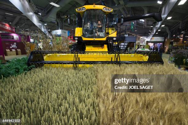Man inside of a combine harvester cleans the window at the Salon de l'Agriculture on February 24 in Paris. Nearly 4,000 livestocks will be present at...