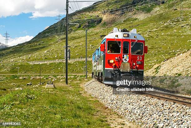 Zug der Rhaetischen Bahn am Lago Bianco am Bernina Pass in den schweizer Alpen, Schweiz.Alpine train at Lago Bianco at the Bernina Pass in the Swiss...